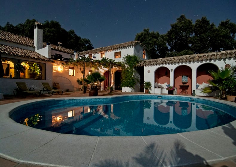 Spanish-style villa with a pool at night